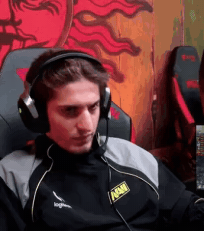 A Man Wearing Headphones And A Microphone Is Sitting In A Chair In Front Of A Computer . GIF