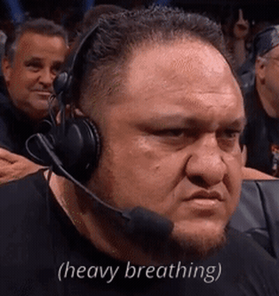 A Man Wearing Headphones And A Microphone Is Sitting In A Stadium . GIF