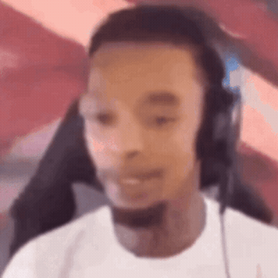 A Man Wearing Headphones And A Microphone Is Sitting In Front Of A Computer Screen . GIF