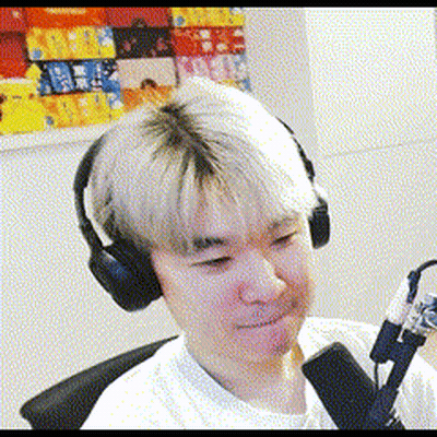 A Man Wearing Headphones And A Microphone Is Sitting In Front Of A Painting . GIF