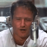 A Man Wearing Headphones And A Microphone Is Talking Into A Microphone . GIF
