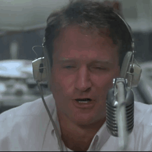 A Man Wearing Headphones And A Microphone Looks At The Camera GIF