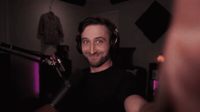 A Man Wearing Headphones And A Microphone Looks At The Camera GIF