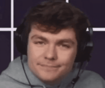 A Man Wearing Headphones And A Microphone Looks At The Camera . GIF