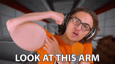 A Man Wearing Headphones And A Microphone Says " Look At This Arm " GIF