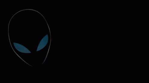 A Man Wearing Headphones And A Monster Shirt Stands In Front Of An Alien GIF