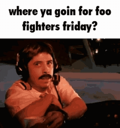 A Man Wearing Headphones And A Mustache Is Sitting In A Plane . GIF
