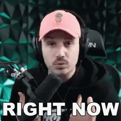 A Man Wearing Headphones And A Pink Hat Is Standing In Front Of A Microphone And Says `` Right Now '' . GIF