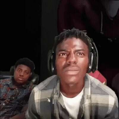 A Man Wearing Headphones And A Plaid Shirt Is Looking At The Camera While Another Man Looks On . GIF