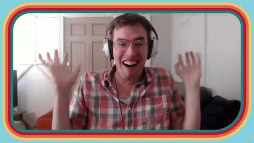 A Man Wearing Headphones And A Plaid Shirt Is Smiling And Waving GIF