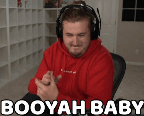 A Man Wearing Headphones And A Red Hoodie With The Words Booyah Baby Above Him GIF