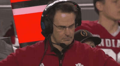 a man wearing headphones and a red jacket that says indiana