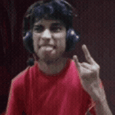 A Man Wearing Headphones And A Red Shirt Is Looking At The Camera . GIF