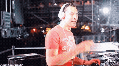 A Man Wearing Headphones And A Red Shirt Is Playing Music . GIF