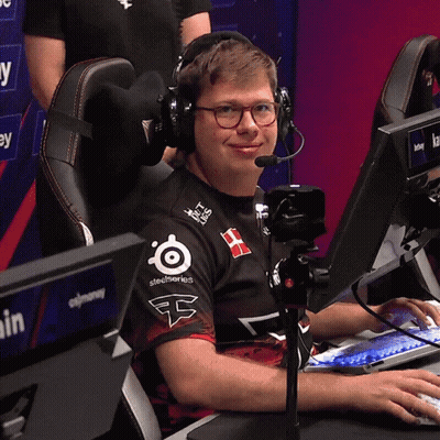 A Man Wearing Headphones And A Shirt That Says Steelseries Sits In Front Of A Computer GIF