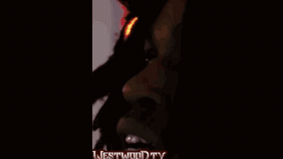 A Man Wearing Headphones And A Superman Shirt Is Standing In Front Of A Microphone With The Words Westwood Tv On The Bot GIF
