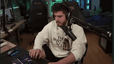 a man wearing headphones and a sweater that says the north face is typing on a keyboard