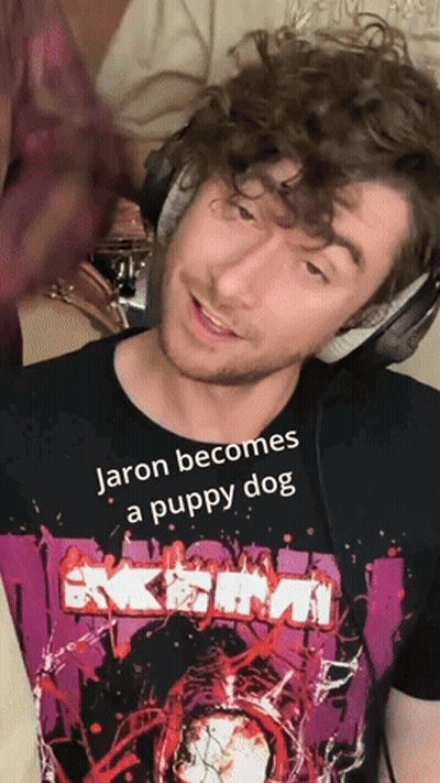 A Man Wearing Headphones And A T-Shirt That Says Jaron Becomes A Puppy Dog GIF