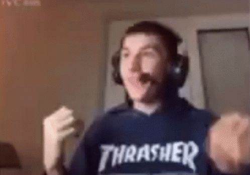 A Man Wearing Headphones And A Thrasher Sweatshirt Is Making A Fist . GIF