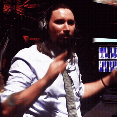 A Man Wearing Headphones And A Tie Is Dancing In Front Of A Red Bull Machine GIF