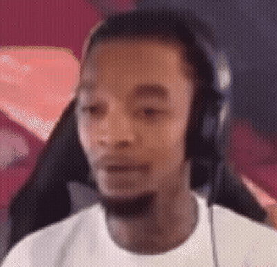 A Man Wearing Headphones And A White Shirt Is Looking At The Camera . GIF