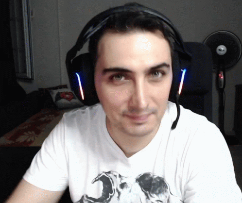 A Man Wearing Headphones And A White Shirt With A Picture Of A Skull On It GIF
