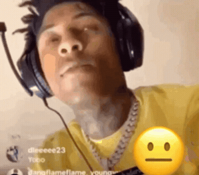 A Man Wearing Headphones And A Yellow Shirt Has A Smiley Face On His Chest . GIF