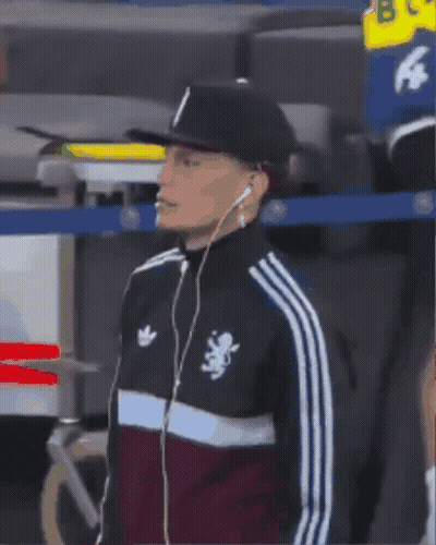 A Man Wearing Headphones And An Adidas Jacket With A Lion On The Front GIF