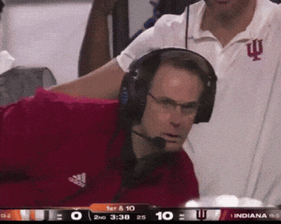 A Man Wearing Headphones And An Adidas Shirt Is Watching A Game GIF