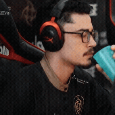 A Man Wearing Headphones And Glasses Is Holding A Blue Cup GIF