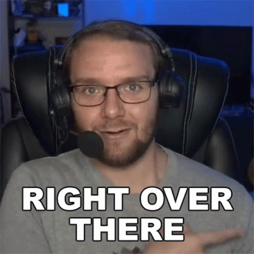 A Man Wearing Headphones And Glasses Is Pointing To The Right And Saying Right Over There GIF