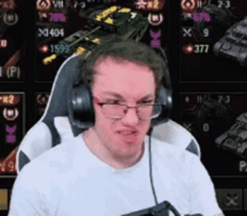 A Man Wearing Headphones And Glasses Is Sitting In Front Of A Computer . GIF