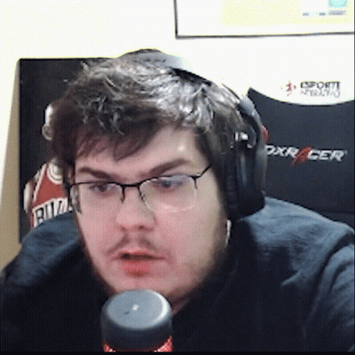 A Man Wearing Headphones And Glasses Is Sitting In Front Of A Dxracer Chair GIF