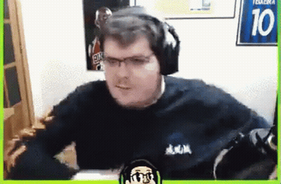 A Man Wearing Headphones And Glasses Is Sitting In Front Of A Microphone In A Room . GIF