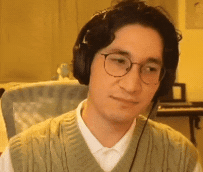 A Man Wearing Headphones And Glasses Is Sitting In Front Of A Piano . GIF