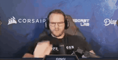A Man Wearing Headphones And Glasses Is Sitting In Front Of A Screen That Says Corsair GIF