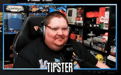 A Man Wearing Headphones And Glasses Is Sitting In Front Of A Screen That Says Tipster GIF