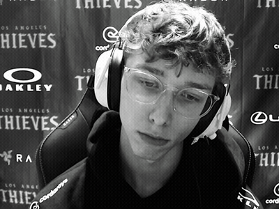 A Man Wearing Headphones And Glasses Is Sitting In Front Of A Wall That Says Thieves GIF