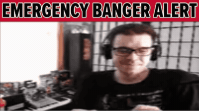 A Man Wearing Headphones And Glasses Is Smiling In Front Of A Sign That Says Emergency Banger Alert GIF