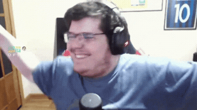 A Man Wearing Headphones And Glasses Is Smiling In Front Of A Sign With The Number 10 On It GIF