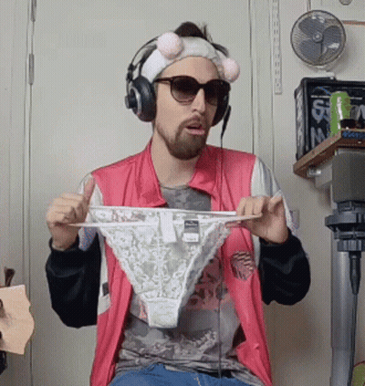 A Man Wearing Headphones And Sunglasses Is Holding Up A Pair Of Underwear GIF