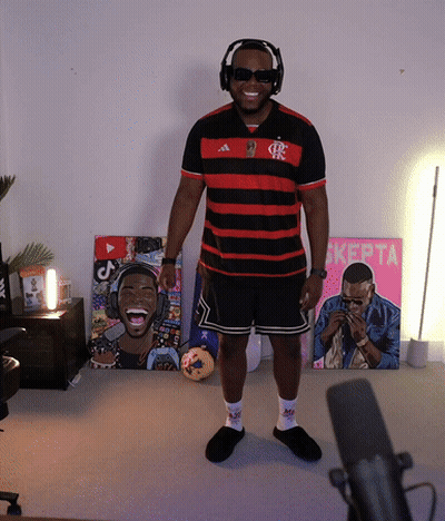 A Man Wearing Headphones And Sunglasses Stands In Front Of A Pink Sign That Says ' Kepta ' GIF