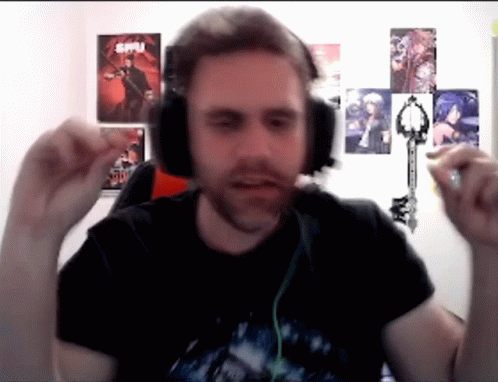 A Man Wearing Headphones Holds A Key In Front Of A Wall With Posters On It That Say Spy GIF