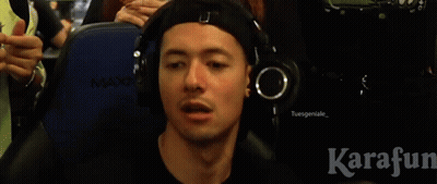 A Man Wearing Headphones Is Blowing Into A Pink Whistle GIF
