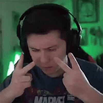 A Man Wearing Headphones Is Covering His Ears With His Hands While Making A Funny Face . GIF