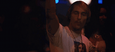 A Man Wearing Headphones Is Dancing In A Club While A Woman Watches . GIF