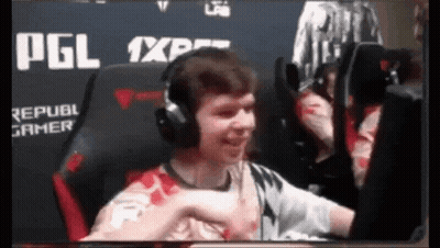 A Man Wearing Headphones Is Giving A Fist Bump GIF