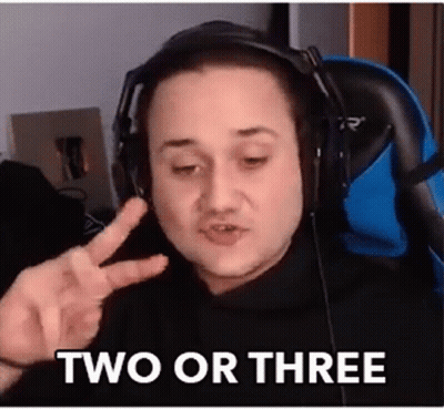 A Man Wearing Headphones Is Giving A Peace Sign While Sitting In A Chair . GIF