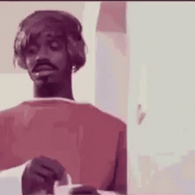 A Man Wearing Headphones Is Holding A Cigarette In His Hand . GIF