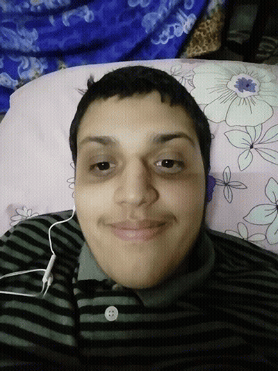 A Man Wearing Headphones Is Laying On A Bed GIF